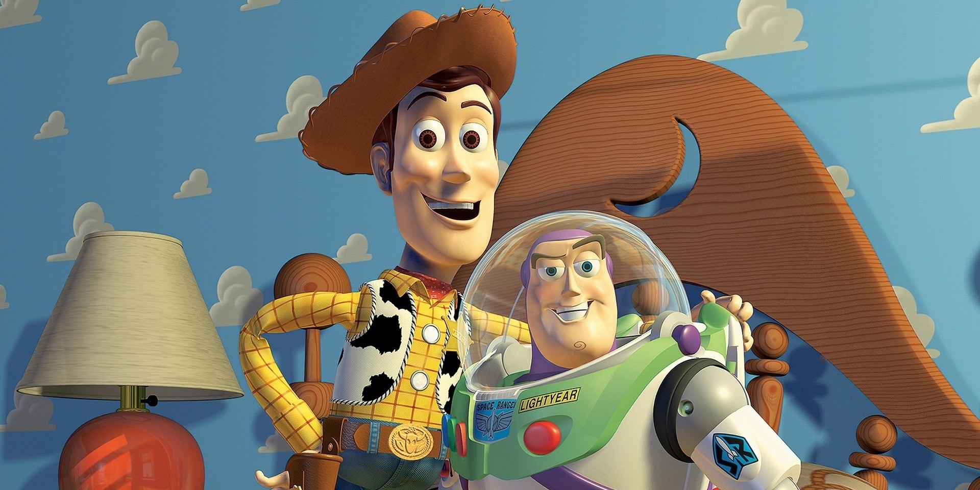 Les deux personnages principaux du film « Histoire de jouets » Woody et Buzz prennent une photo ensemble. Il y a une lumière et une partie d'un lit en arrière d'eux. Le fond est d'un bleu pâle avec des nuages blancs.